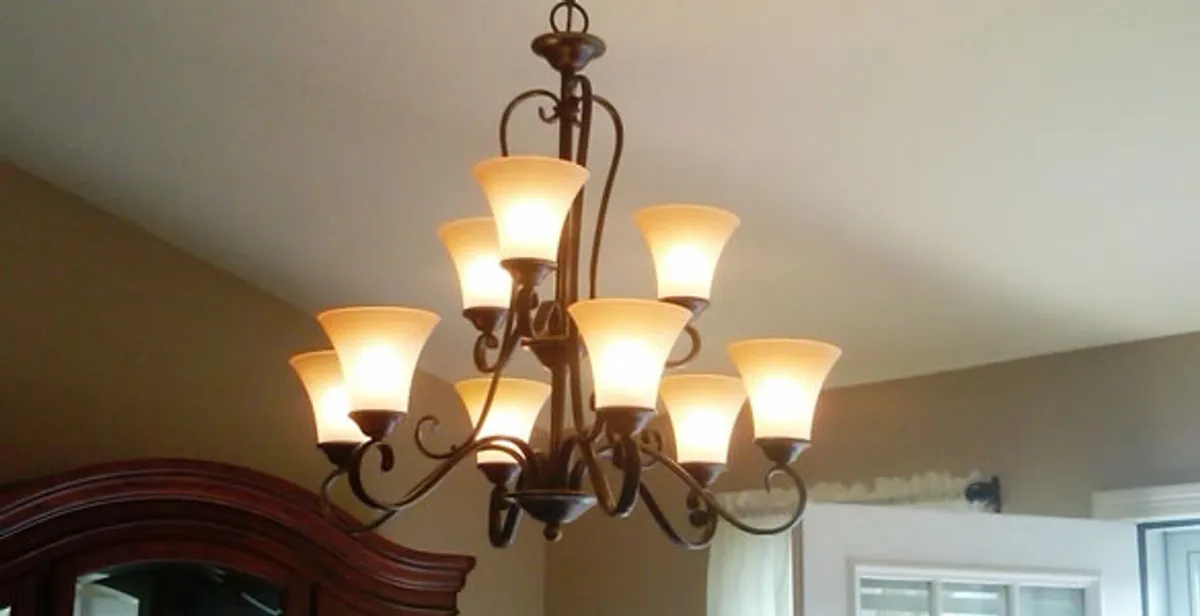 Classic ceiling chandelier installation with warm lighting in Austin, TX