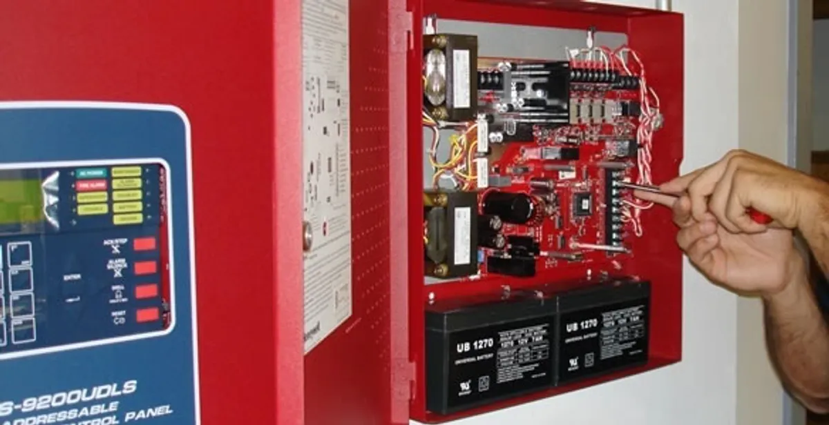 fire alarm installation service showing technician configuring fire alarm control panel in Austin, TX