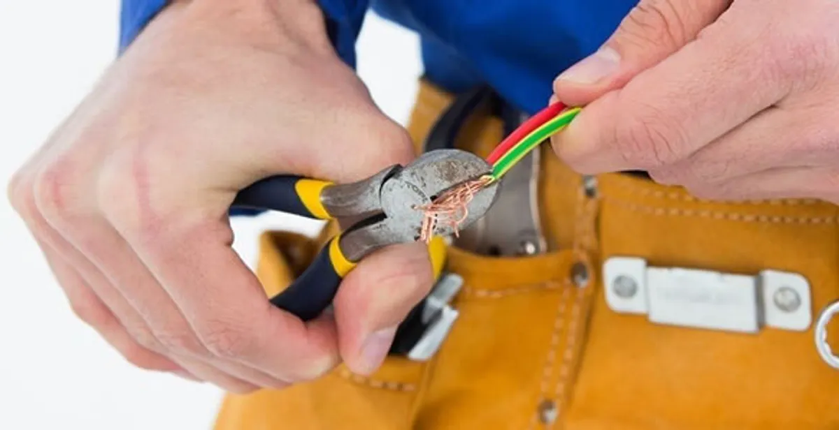 licensed electrician securing electrical wiring with professional tools during service work in Austin, TX