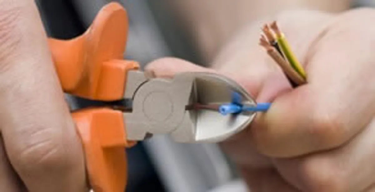 licensed electrician performing precise wire cutting and preparation during electrical service in Austin, TX