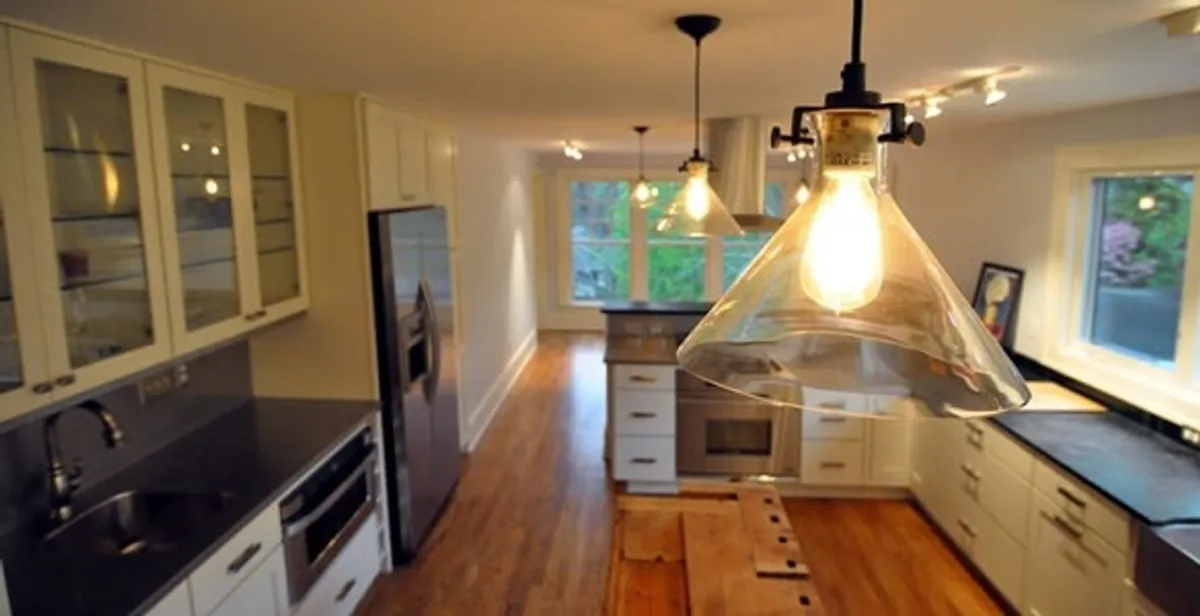 Residential electrician installing modern indoor light fixture in a home in Austin, TX