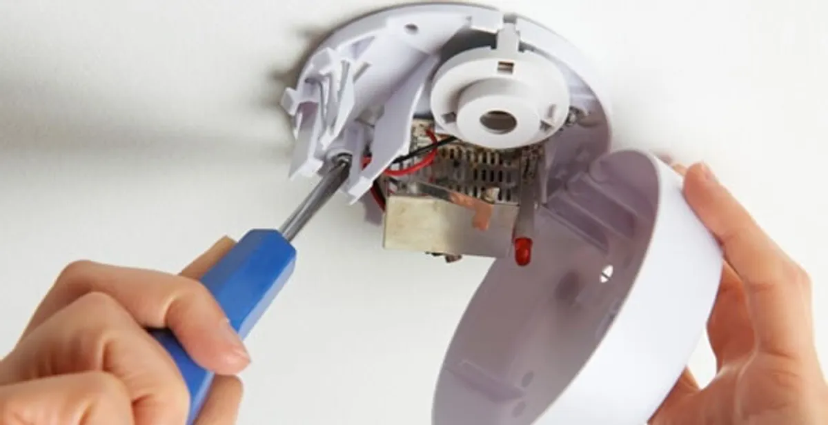 Certified technician wiring smoke detector during installation in Austin, TX